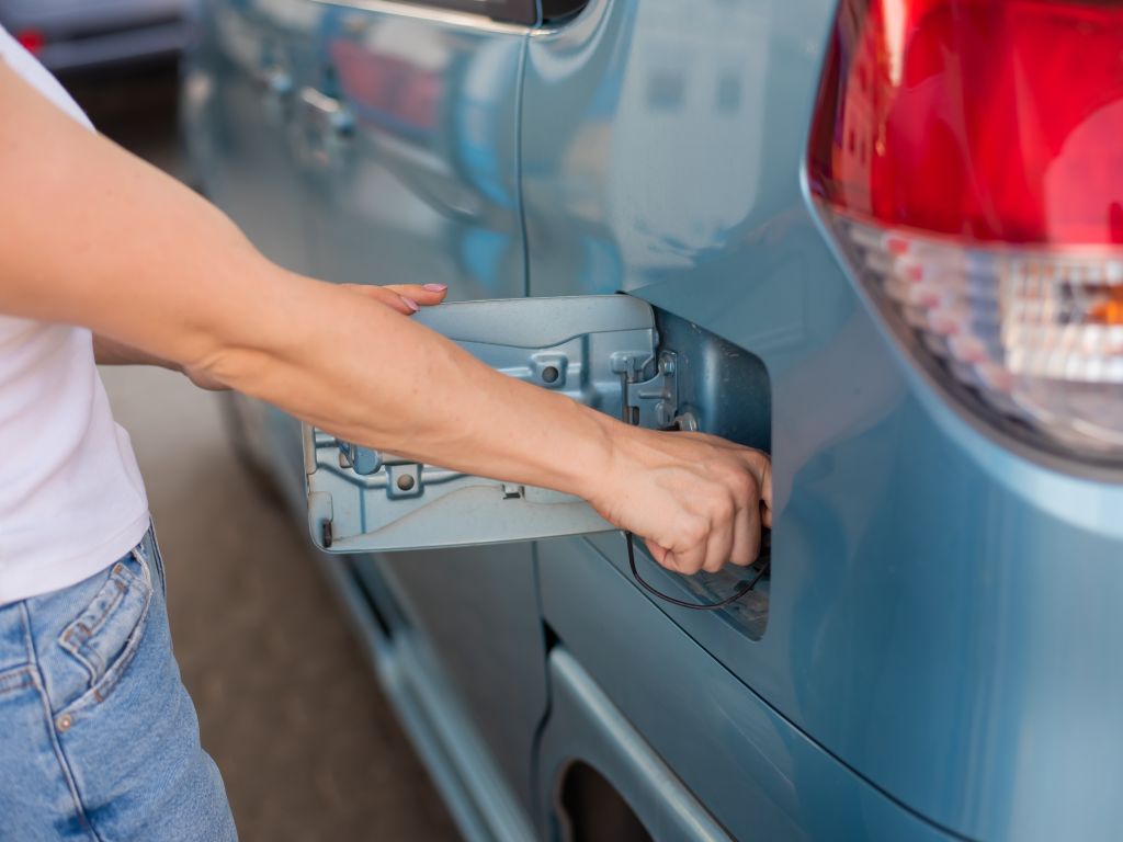 persona abriendo dispensador para echar gasolina a una furgoneta